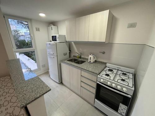 eine kleine Küche mit einem Herd und einem Kühlschrank in der Unterkunft Departamento Céntrico Pampa Haus in Santa Rosa