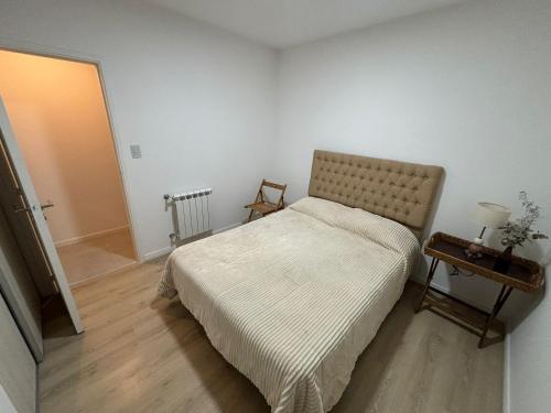 ein kleines Schlafzimmer mit einem Bett und einem Nachttisch in der Unterkunft Departamento Céntrico Pampa Haus in Santa Rosa