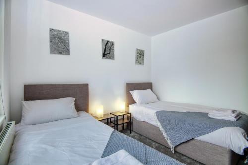 dos camas sentadas una al lado de la otra en un dormitorio en 2 bed flat in Islington en Londres