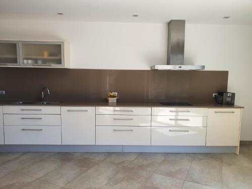 a kitchen with white cabinets and a sink at Finca S' Estoneta con increíbles vistas al mar in Capdepera