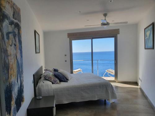 a bedroom with a bed with a view of the ocean at Finca S' Estoneta con increíbles vistas al mar in Capdepera