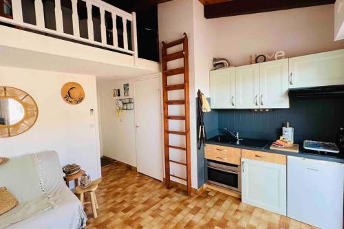 - une cuisine avec un évier et des lits superposés dans une chambre dans l'établissement Appartement proche village natu, au Cap d'Agde