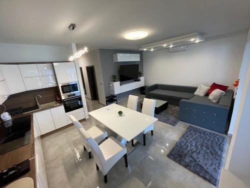a kitchen and a living room with a table and chairs at VRG 1 Exkluzív Apartman in Debrecen