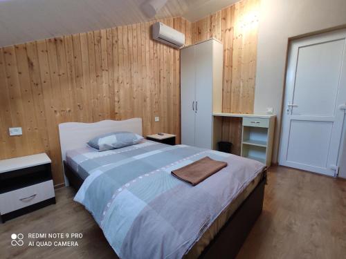 a bedroom with a large bed and wooden walls at Гостевой дом LIMANN in Odesa