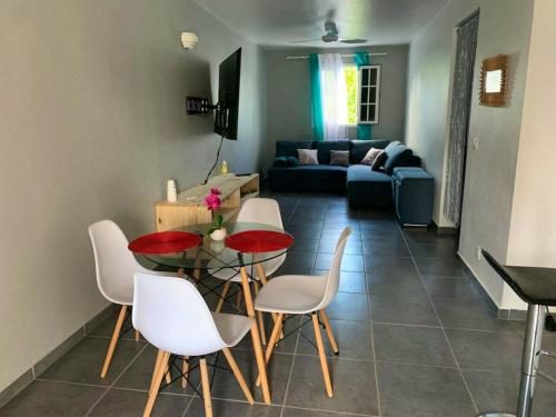 een woonkamer met een tafel en stoelen en een bank bij Studio avec jardin et wifi a Le Moule a 5 km de la plage in Le Moule