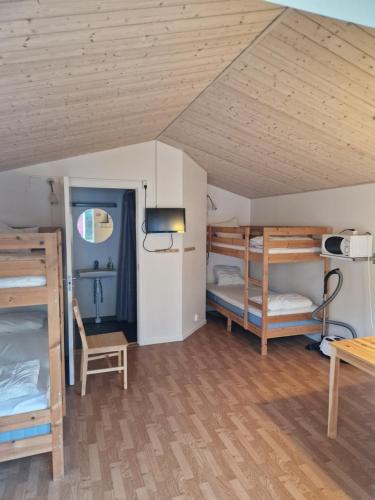 a room with three bunk beds and a table at Lovsjöbadens Camping in Jönköping