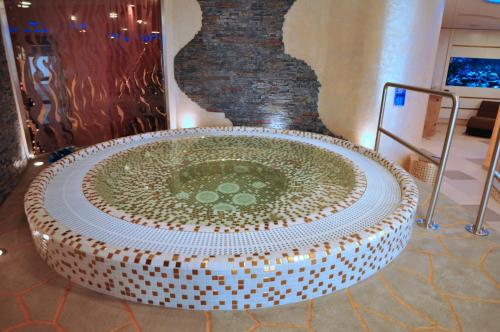 a large stone tub with a fountain in a room at Boutique Hotel Ambiente ****+ in Karlovy Vary
