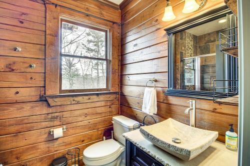 La salle de bains est pourvue de toilettes, d'un lavabo et d'un miroir. dans l'établissement North Georgia Log Home with Long Range Views, à Ranger