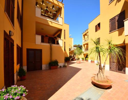 馬里內拉迪塞利的住宿－Antonella houses，棕榈树和鲜花的建筑的庭院