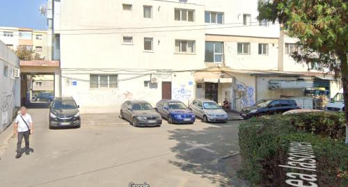 a man riding a skateboard down a street with parked cars at Apartament Wide View in Buzău