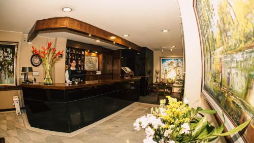 eine Lobby mit einer Bar mit einer Blumenvase in der Unterkunft Hotel Boyaca Plaza in Tunja