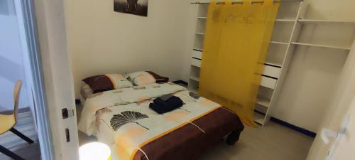 ein Schlafzimmer mit einem Bett und einem Rucksack darauf in der Unterkunft Chambre#2 zen / logement partagé in Villeneuve-Saint-Georges