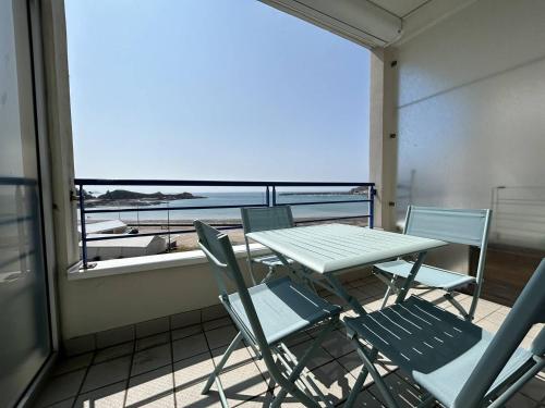 une table et des chaises sur un balcon avec vue sur l'océan dans l'établissement 510 - Appartement T3 à Erquy avec pleine vue mer, à Erquy