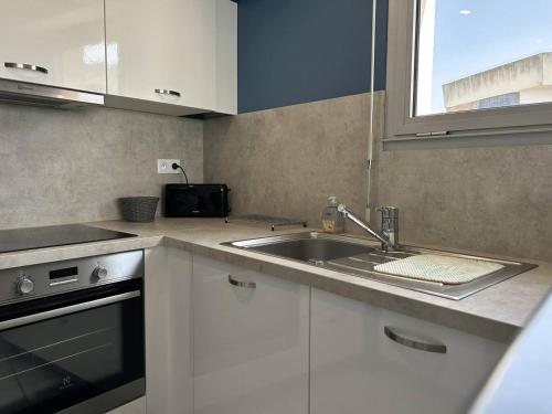 une cuisine avec un évier et un plan de travail dans l'établissement 510 - Appartement T3 à Erquy avec pleine vue mer, à Erquy