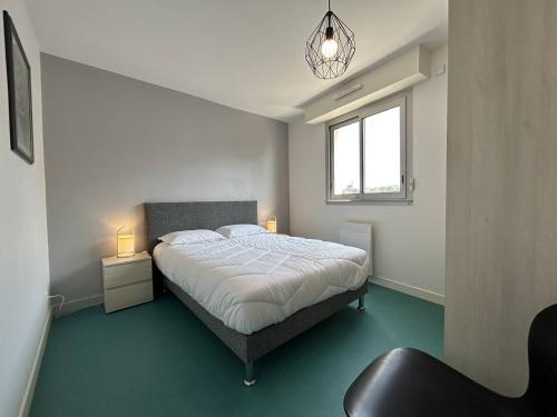 une chambre avec un grand lit et une fenêtre dans l'établissement 510 - Appartement T3 à Erquy avec pleine vue mer, à Erquy