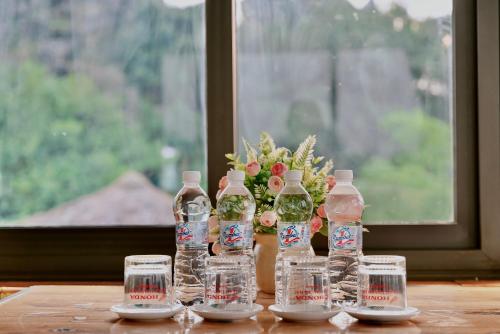 a group of water bottles and glasses on a table at Hang Mua Bamboo Homestay Ninh Binh in Ninh Binh