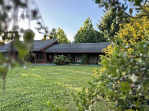 a house with a green lawn in front of it at Magnolia Bed & Breakfast in Villarrica