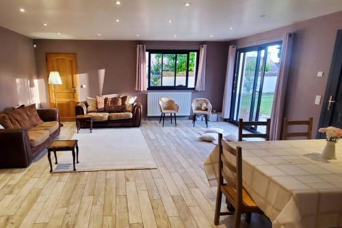 un grand salon avec une table et un salon dans l'établissement Maison pleine de charme, à Dammartin-en-Serve