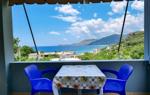 a table and chairs in a balcony with a view of the ocean at Kalemi Sunrise Studios in Borsh