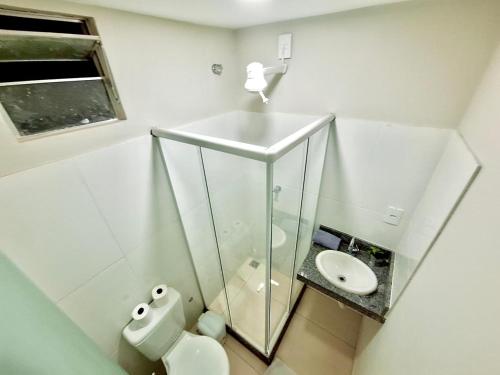 a white bathroom with a sink and a toilet at Studio #1 Conforto in Campos dos Goytacazes