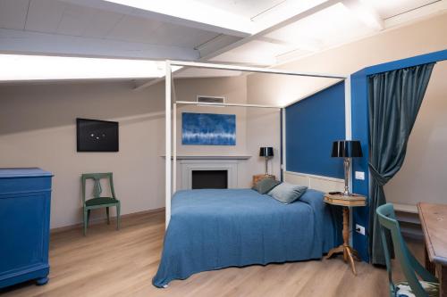 a bedroom with a blue bed and a fireplace at Nido di Borgo35 in Parma