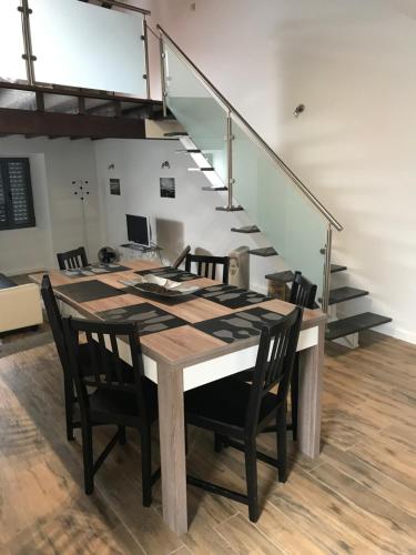a dining room table with chairs and a staircase at CASA DOS CEDROS in Pico da Pedra