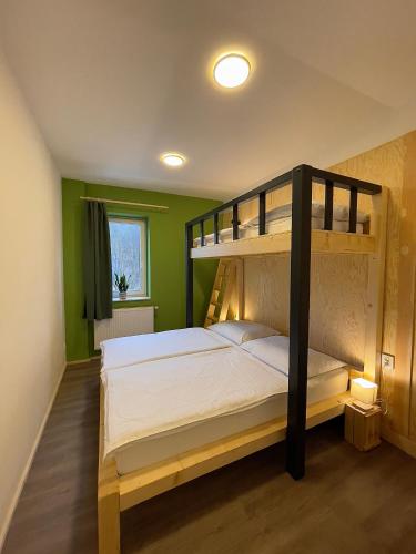 a bedroom with a bunk bed with white sheets at Penzion Mája in Josefuv dul