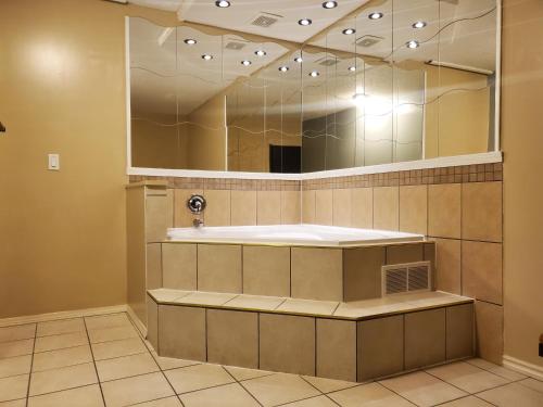 La salle de bains est pourvue d'un lavabo et d'un grand miroir. dans l'établissement Super 8 by Wyndham Duncan, à Duncan