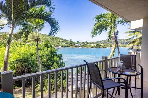 a balcony with a table and chairs and a view of the water at Blue Moon Villa at Point Pleasant Resort condo in Frydendal