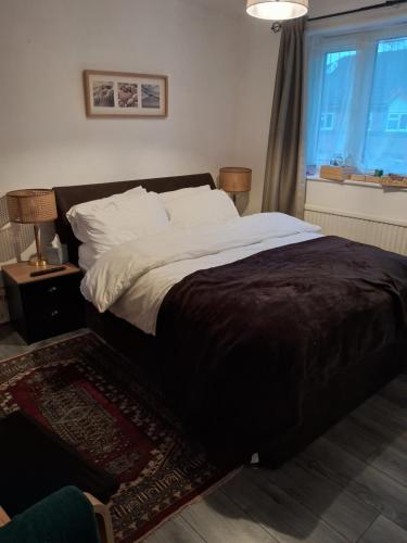 a large bed in a bedroom with a window at 4 mereside walk in Manchester