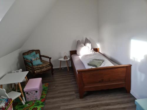 a small bedroom with a bed and a chair at Pilgrims "Rosalie" große Fewo mit 3 Schlafzimmern, 1Bad, 2 WC, Balkon, fast Internet in Brilon