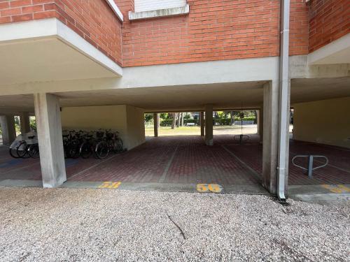 un estacionamiento con bicicletas estacionadas en un edificio en La Zagara Bibione, near beach, en Bibione