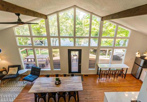 a living room with a table and chairs and windows at Waterfront Haliburton, All Season, Fully Equipped Cottage! in Haliburton