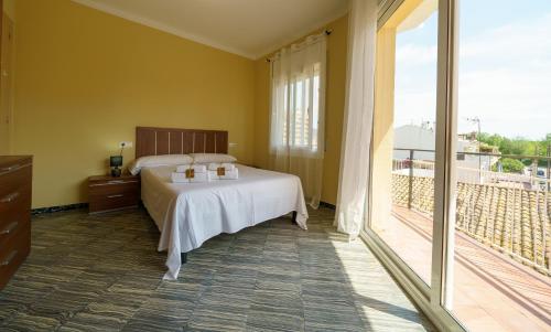 um quarto com uma cama e uma grande janela em HomeHolidaysRentals Pineda II em Pineda de Mar