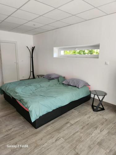 1 dormitorio con 1 cama con edredón verde en Le Mazet, en Saint-Ambroix