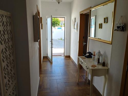 a hallway with a wooden floor and a table and a door at Casa Sarguito in Sagres