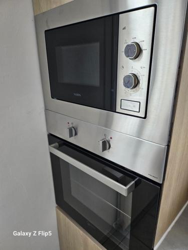 un horno microondas sobre una estufa en VILLA Zara, en Beauvais
