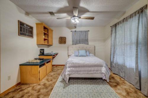 a bedroom with a bed and a ceiling fan at Rustic Flames & 4-Bedroom Comfort in West Monroe