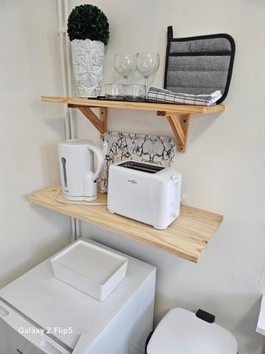 a shelf above a toilet with a toaster and cups at VILLA Zara in Beauvais