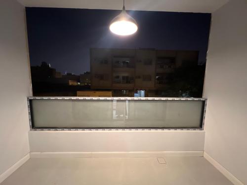 una ventana con vistas a la ciudad por la noche en الفاتن لشقق الخاصه en Riad