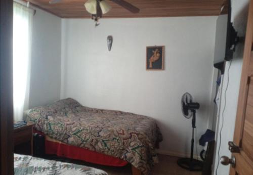 a small bedroom with two beds and a fan at Habitacion 2 Personas B&B in Nuevo Arenal