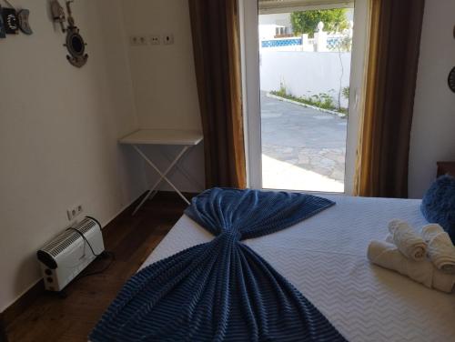 a bedroom with a bed with towels on it at Casa Sarguito in Sagres