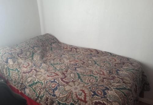 uma cama com um cobertor num quarto em Habitacion 2 Personas B&B em Nuevo Arenal