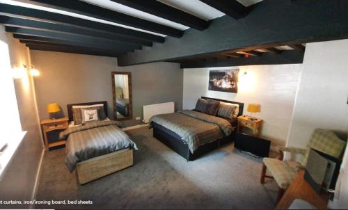 una camera con due letti, un divano e un tavolo di Fairy Falls Hotel a Trefriw