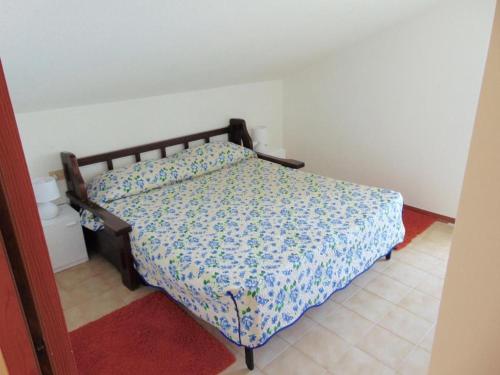 um quarto com uma cama com colcha floral em Comoda mansarda fronte mare, Marcelli - M249 em Marcelli