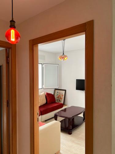 ein Wohnzimmer mit einem roten Sofa und einem Tisch in der Unterkunft Lovely family apartment in Tetouan in Tétouan