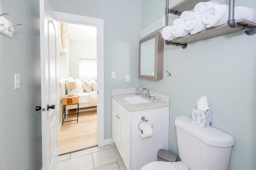 a white bathroom with a toilet and a sink at [S] Cozy Studio for a Peaceful Lawrence Getaway! in Lawrence