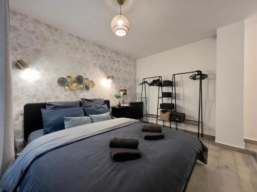 une chambre avec un grand lit avec deux serviettes dessus dans l'établissement La Cloche Dorée, parking, 3 étoiles, en plein cœur de Fontainebleau, à Fontainebleau