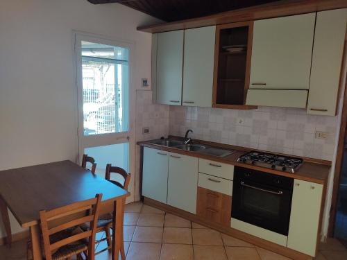 a kitchen with white cabinets and a table and a sink at Appartamento a due passi dal mare, Forio in Ischia