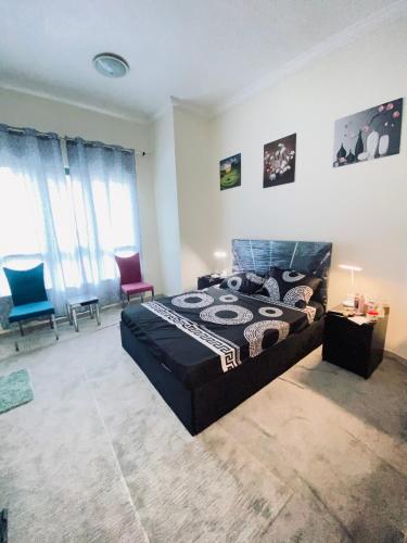 sypialnia z dużym łóżkiem i 2 krzesłami w obiekcie Jovian guest house w Dubaju